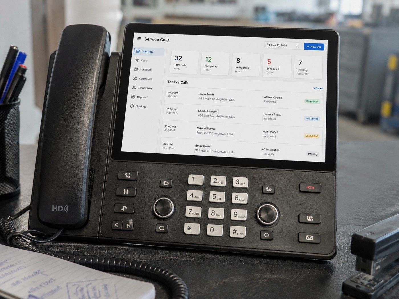 An office phone on an HVAC front desk with the day’s service calls on screen.